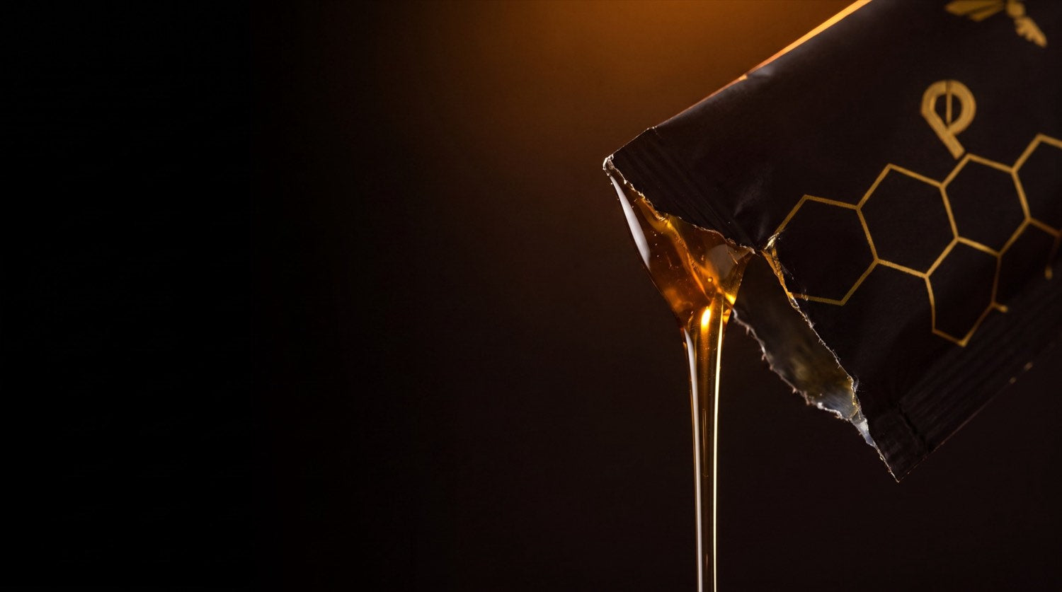 Golden honey pouring from a torn Prime Honey sachet